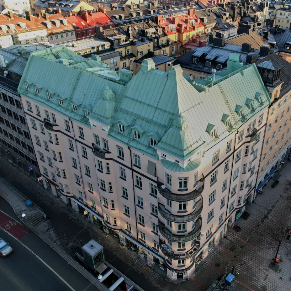 Luftbild över sekelskifteshus i stadsmiljö med grönt plåttak - exempel på fastigheter där Kinnunens Plåtslageri AB utför takarbeten och plåtslageri